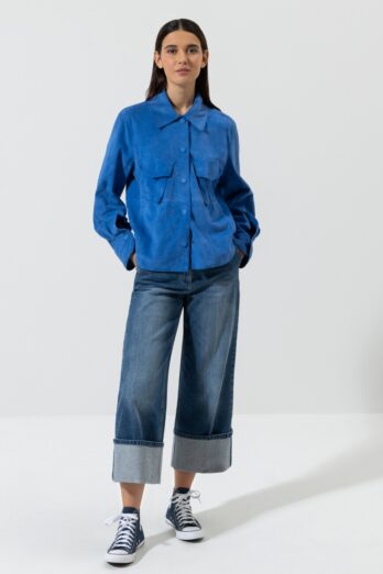 Koszula Luisa Cerano wykonana z luksusowej, miękkiej koziej skóry w intensywnym kolorze niebieskim, zaokrąglonym dolnym obszyciem z rozcięciami bocznymi oraz dwiema kieszeniami z klapką na piersi. Zatrzaski z przodu pokryte są skórą.